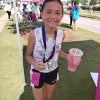 Girls on the Run participant holding program 5K medal
