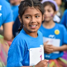 Girls on the Run participant high fives running buddy at 5K  